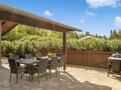 a patio with a table and chairs and a grill at Holiday Home Yngve - 3-5km from the sea by Interhome in Fjerritslev