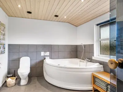 a bathroom with a white tub and a toilet at Holiday Home Yngve - 3-5km from the sea by Interhome in Fjerritslev