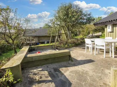a patio with a bench and a table and chairs at 7 person holiday home in Lemvig-By Traum in Lemvig