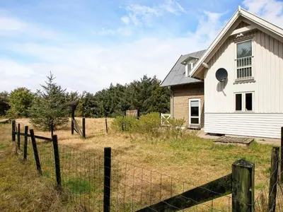 a white house with a fence in a field at 5 person holiday home in Harboøre in Harboør