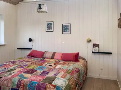 a bedroom with a bed with a colorful quilt at 6 person holiday home in Spøttrup-By Traum in Knud