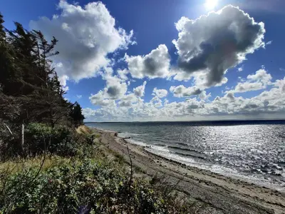 a beach with a cloudy sky and the ocean at 6 person holiday home in Spøttrup-By Traum in Knud