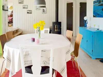 a white table with a vase of flowers on it at 6 person holiday home in Spøttrup-By Traum in Knud