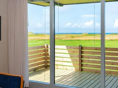 a screened porch with a view of the ocean at 6 person holiday home in Lemvig-By Traum in Trans