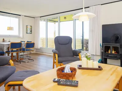 a living room with a table and a fireplace at 6 person holiday home in Lemvig-By Traum in Trans