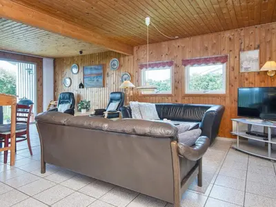 a living room with a leather couch and a television at Cozy Renovated Cottage - By Traum Ferienwohnungen in Harboør