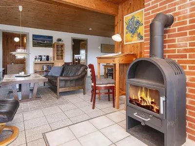 a living room with a wood stove in a room at Cozy Renovated Cottage - By Traum Ferienwohnungen in Harboør