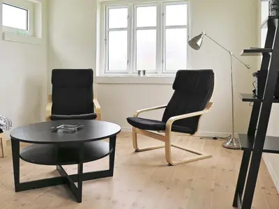 a living room with two chairs and a table at 4 person holiday home in Lemvig-By Traum in Trans