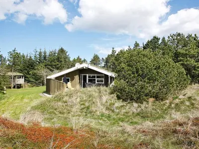 a small house on a hill in a field at 6 person holiday home in Blokhus-By Traum in Blokhus