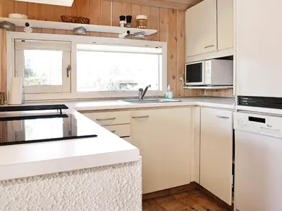a kitchen with white cabinets and a sink at 6 person holiday home in Blokhus-By Traum in Blokhus