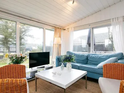 a living room with a blue couch and a tv at 4 person holiday home in Blokhus-By Traum in Blokhus