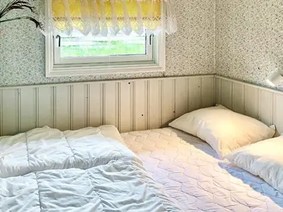 two beds sitting in a room with a window at 4 person holiday home in Blokhus-By Traum in Blokhus