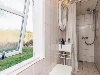 a bathroom with a shower and a toilet and a window at 4 person holiday home in Blokhus-By Traum in Blokhus