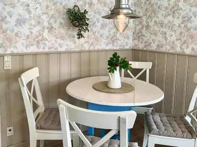 a dining room table with two chairs and a potted plant at 4 person holiday home in Blokhus-By Traum in Blokhus