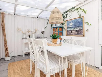 a white dining room with a white table and chairs at 4 person holiday home in Blokhus-By Traum in Blokhus