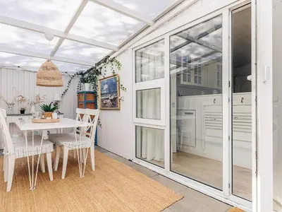 a kitchen with a table and chairs and sliding glass doors at 4 person holiday home in Blokhus-By Traum in Blokhus