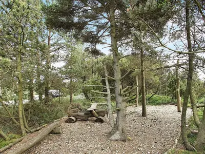 a wooden bench sitting in the middle of a forest at 10 person holiday home in Fjerritslev-By Traum in Torup Strand