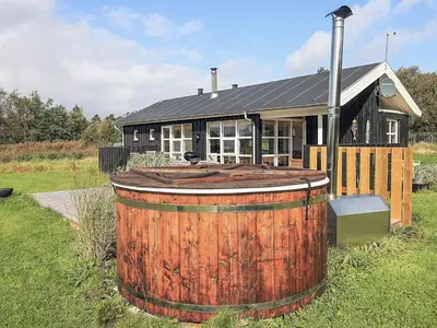 a large wooden barrel in front of a house at 6 person holiday home in Øster Assels-By Traum in Sillerslev