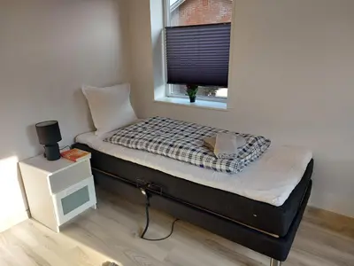 a small bed in a room with a window at Venos Home in Lemvig