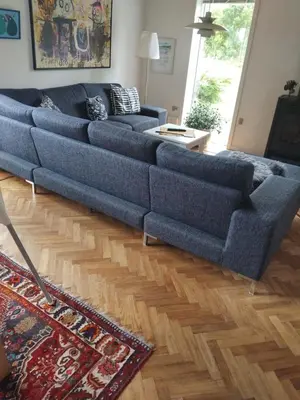 a blue couch sitting in a living room at Dejligt og stort hus med spa og sauna in Roslev