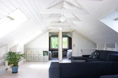 a living room with a couch and a ceiling at Dejligt og stort hus med spa og sauna in Roslev