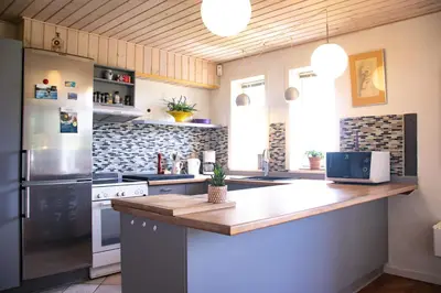 a kitchen with a counter and a refrigerator at Dejligt og stort hus med spa og sauna in Roslev