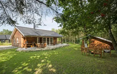 a log cabin with a table and chairs in a yard at 3 Bedroom Gorgeous Home In Skals in Skals