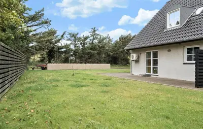 a house with a grass yard next to a building at Stunning Home In Harboøre With Wifi in Harboør