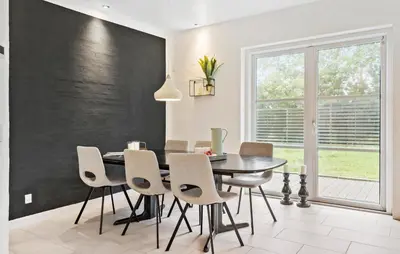 a dining room with a black wall and a table and chairs at Stunning Home In Harboøre With Wifi in Harboør