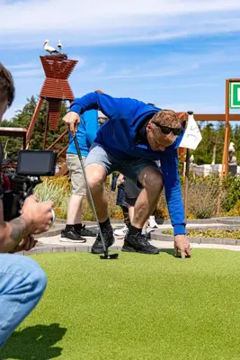 a man is playing golf on the grass at Stort sommerhus - Legeland for store og små in Pandrup