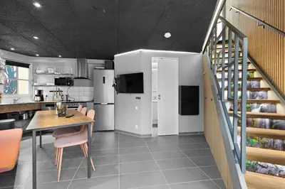 a kitchen and dining room with a table and a staircase at Funart 4 in Pandrup