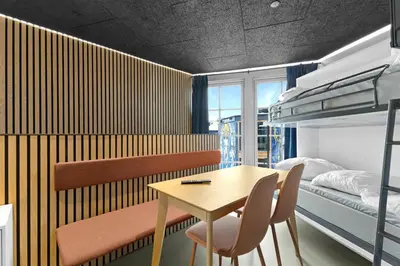 a bedroom with a table and chairs and a bunk bed at Funart 7 in Pandrup