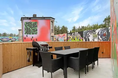 a patio with a table and chairs and a grill at Funart 7 in Pandrup