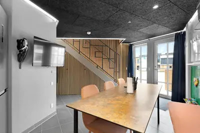 a dining room with a table and a staircase at Funart 13 in Pandrup