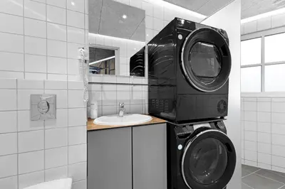 a bathroom with a washing machine and a sink at Funart 10 in Pandrup