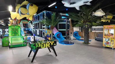 a childrens play room with slides and palm trees at Funart 15 in Pandrup