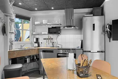a kitchen with a stainless steel refrigerator and a table at Funart 8 in Pandrup