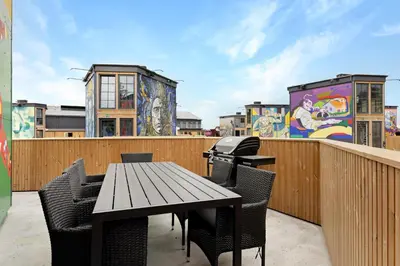 a patio with a wooden table and chairs on a balcony at Funart 8 in Pandrup
