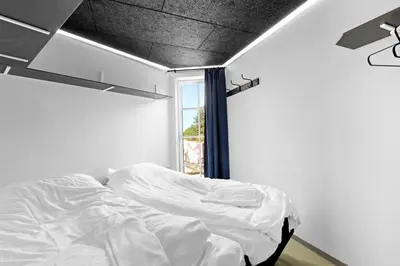 a white bed in a room with a window at Funart 11 in Pandrup