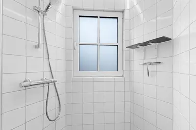 a shower with a window in a white bathroom at Funart 11 in Pandrup