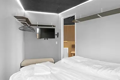 a bedroom with a white bed and a tv at Funart 9 in Pandrup