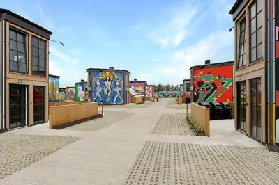 a street with paintings on the sides of buildings at Funart 6 in Pandrup