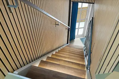 a staircase in a building with wooden walls and a window at Funart 12 in Pandrup