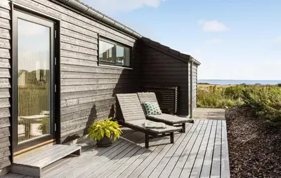 a wooden deck with two chairs on a house at Beautiful Home In Nykøbing M With Wifi in Alsted