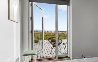 a room with a balcony with a view of the ocean at Beautiful Home In Nykøbing M With Wifi in Alsted