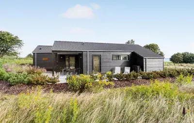 a black house in the middle of a field at Beautiful Home In Nykøbing M With Wifi in Alsted
