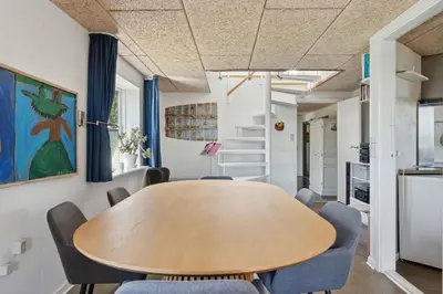 a dining room with a wooden table and chairs at Spacious Holiday Home With Views Over Limfjorden in Jørsby