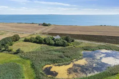 an aerial view of a farm with the ocean in the background at Spacious Holiday Home With Views Over Limfjorden in Jørsby