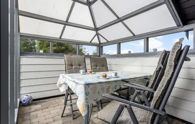 a screened in porch with a table and chairs at 2 Bedroom Amazing Home In Thisted in Thisted