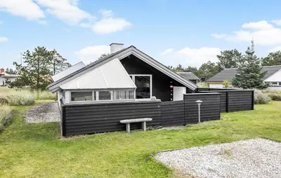 a black house with a bench in front of it at 2 Bedroom Amazing Home In Thisted in Thisted